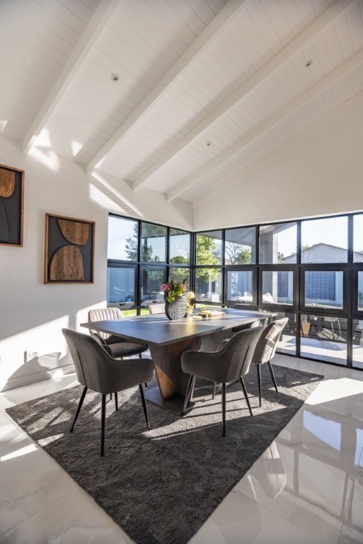 Dining area with a sculptural wood table beneath the vaulted ceiling