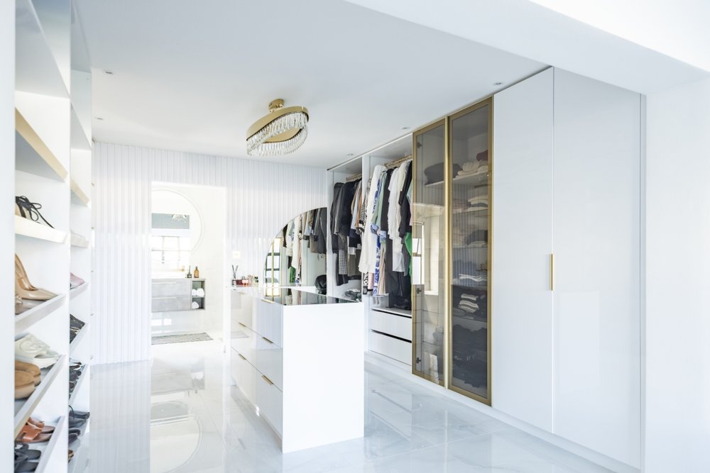 Walk-in dressing room with an island and mirrored doors