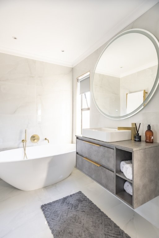 Bathroom with a freestanding tub and round mirror
