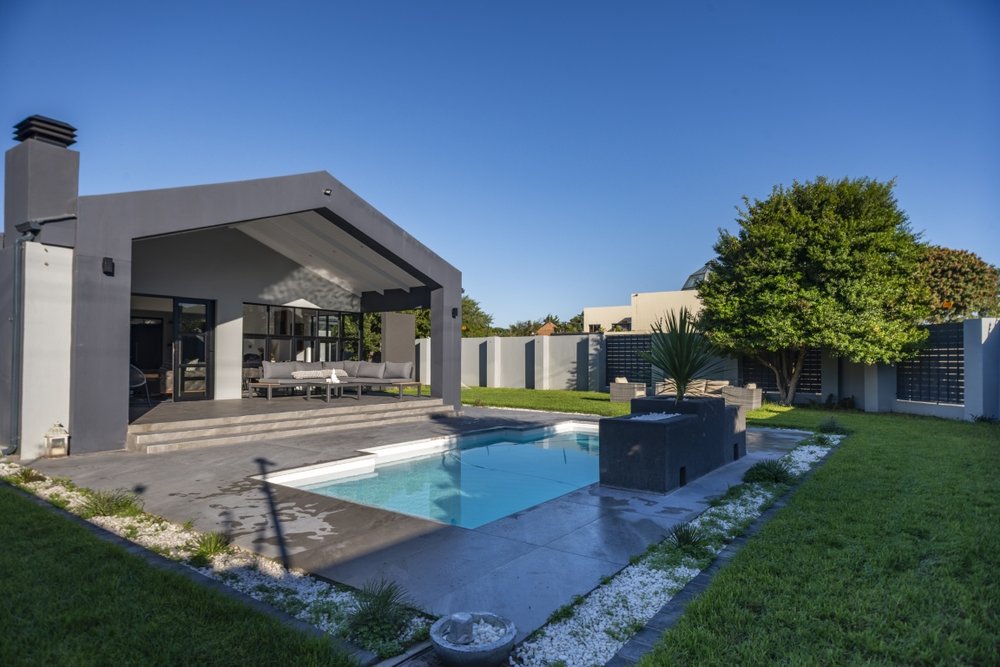 Pool viewed from the side, with the covered patio lounge beyond