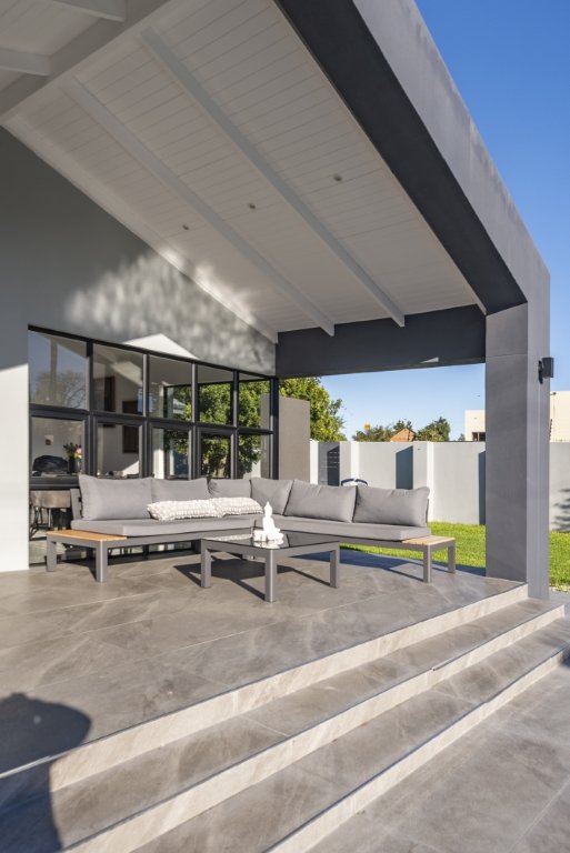 Covered patio lounge seating with a view to the garden